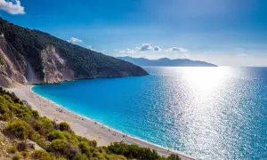 Widok na Myrtos, jedną z najpiękniejszych plaż w Grecji. Turkusowe morze, biały piasek i zielone wzgórza tworzą rajski krajobraz.
