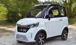 Piccola macchina bianca e nera, perfetta per chi cerca una soluzione di mobilità urbana senza patente.