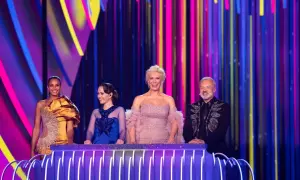 Cztery osoby na scenie z kolorowym tłem. Jedna z nich, w złotej sukni, może reprezentować Polskę na Eurowizji.
