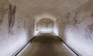 Gewölbter Gang mit Skizzen an den Wänden, die an Michelangelos Grab erinnern.