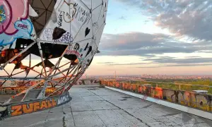 Graffiti-bedeckte Kuppel des Teufelsberg Berlin mit Blick auf die Stadt bei Sonnenuntergang.