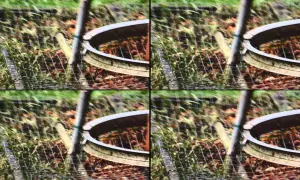 Zniekształcony obraz z efektem rolling shutter, ukazujący fragment ogrodzenia i ziemi.