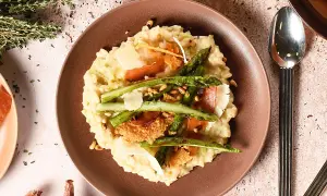 Un crémeux risotto aux asperges vertes, garni de copeaux de parmesan et de fines tranches de prosciutto. Une recette parfaite pour un repas printanier.