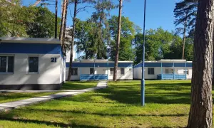 Urocze domki letniskowe w Międzyzdrojach, otoczone zielenią, zapraszają na wypoczynek. Numer 21 widoczny na jednym z budynków.