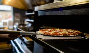 Piec z pizzą na łopacie, gotową do wyjęcia.