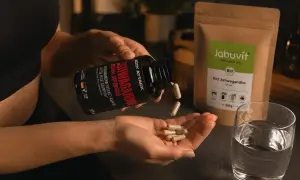 Frau nimmt Ashwagandha-Kapseln ein. Wann einnehmen? Am besten morgens oder abends für Stressabbau und Wohlbefinden.