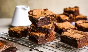 Gestapelte, saftige Brownies auf einem Gitter, bereit zum Genießen. Dieses Brownie-Rezept ist ein Traum für jeden Schokoladenliebhaber.