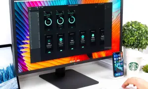 Na monitorze widać projekt aplikacji mobilnej, a obok leży laptop z otwartą **matrycą w laptopie**.