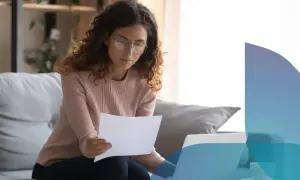 Donna con occhiali legge documenti, lavorando al computer. Scopre che posso intestare le utenze senza avere la residenza.