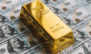 Lingote de oro de 1000g sobre billetes de cien dólares. ¿Cuánto vale 1 kg de oro?