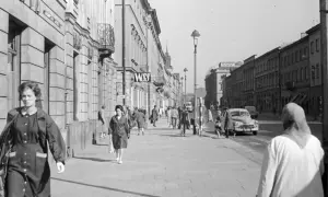 Spacerem po ulicy w nowym świecie, Warszawa. Ludzie idą chodnikiem obok budynków, w tle widać samochody i tramwaj.
