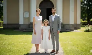 Rodzina przed kościołem. Mama w jasnej sukience, tata w garniturze, a córka w bieli. Idealny przykład, jak się ubrać na komunię syna, gdy to on jest głównym bohaterem.