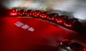 En rad bilar med tända bakljus lyser upp mörkret. Lampor i bilen skapar ett dramatiskt sken.