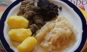 Herzhaftes Gericht: Bratwurst, Blutwurst, Sauerkraut und Salzkartoffeln. Perfekt, um Wellwurst zuzubereiten und zu genießen.