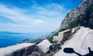 Widok z motocykla na krętą drogę w Chorwacji, z widokiem na morze i góry. Niezapomniana podróż!