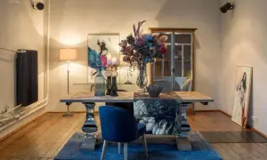 Elegancki stół z bukietem kwiatów i obrazami tworzy jaki obraz do stylu glamour.