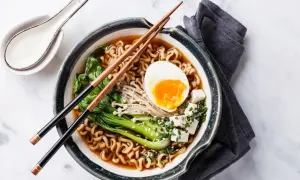 Eine dampfende Schüssel mit köstlicher Ramen-Suppe, garniert mit einem perfekt gekochten Ei, Tofu und Gemüse.