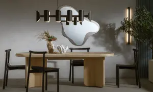 Nowoczesna jadalnia z drewnianym stołem, czarnymi krzesłami i designerską lampą. Ile lamp nad stołem w jadalni? Jedna wisząca.