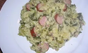 Herzhaftes Gericht mit Kartoffeln, Grünkohl und deftigen Wurstscheiben, die wirsing untereinander gemischt sind.