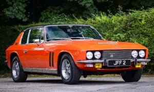 En orange Jensen Interceptor från 70-talet, en klassisk bil med en tidlös design, parkerad utomhus.