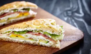 Tramezzini gourmet con prosciutto, uovo, avocado e lattuga su pane soffice. Un'idea per ricette veloci e gustose.