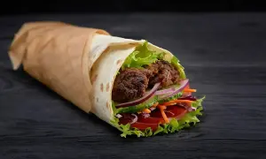Pyszny kebab z kurczakiem, pełen świeżych warzyw i soczystego mięsa. Idealny na szybki posiłek, z myślą o kaloriach.
