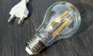 Żarówka LED i biała wtyczka. Pomyśl o doładowanie licznika przedpłatowego, by mieć prąd.