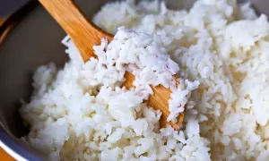 Drewniana łyżka miesza puszysty, biały ryż. Idealny do sushi, wygląda na bardzo dobry ryż.