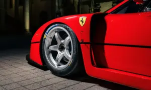 En röd fransk sportbil, en ikonisk Ferrari F40, med sitt legendariska häst-emblem och Michelin-däck.