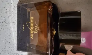Elegancka butelka perfum My Burberry Black z czarną wstążką i złotym napisem.
