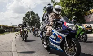 Grupa motocyklistów w nietypowych strojach jedzie ulicą.