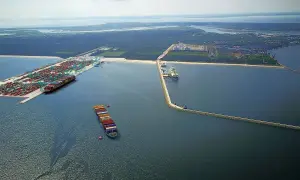 Ogromny port kontenerowy w Świnoujściu z wieloma statkami i dźwigami. W oddali widać terminal LNG.