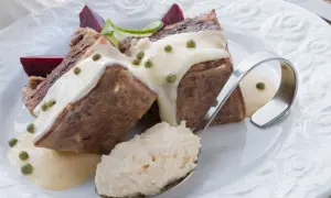 Kawałki mięsa w sosie chrzanowym z zielonym pieprzem, burakami i łyżką tartego chrzanu.