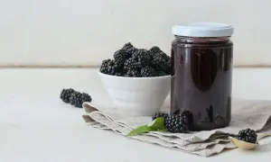 Frische Brombeeren und ein Glas selbstgemachtes Brombeergelee. So lässt sich das Gelee noch verfeinern.