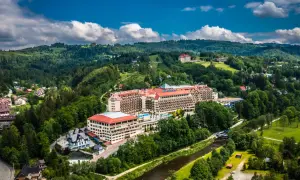 Gdzie są hotele Gołębiewski? Rozległy kompleks hotelowy w otoczeniu zielonych wzgórz i rzeki.