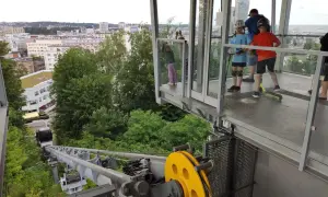 Dzieci z hulajnogami czekają na przejazd kolejką linową Gdynia. Widok na miasto i morze.
