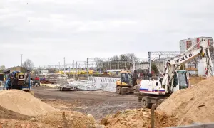 Plac budowy z koparkami i materiałami. Zastanawiasz się, ile zarabia budowlaniec w Anglii?