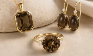 Conjunto de oro con cuarzo ahumado, conocido por sus propiedades de calma y protección. Un colgante, anillo y pendientes que irradian elegancia.