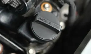 Czarna zakrętka silnika z napisem "ENGINE OIL" i ikonką poziomu oleju. Czas na wymianę zużytego oleju.