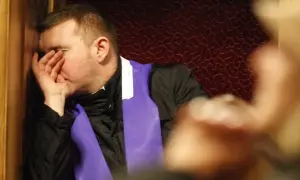 Mężczyzna w konfesjonale, z ręką na twarzy, zastanawia się, jakie są grzechy lekkie.