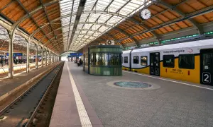 Peron kolejowy w Oławie, pociąg Kolei Dolnośląskich czeka na pasażerów.