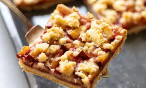 Ein Stück Zwetschgendatschi mit Streuseln wird mit einer Tortengabel herausgehoben. Das Zwetschgendatschi Rezept ist einfach und lecker.