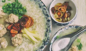 Pyszny congee z klopsikami, szczypiorkiem i chrupiącą cebulką. Idealne na rozgrzewający posiłek.