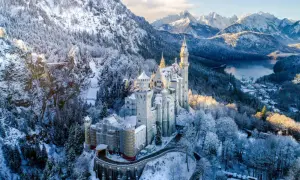 Schloss Neuschwanstein im winterlichen Glanz, ein märchenhafter Ort für einen Urlaub im Dezember. Schnee bedeckt die Berge und Bäume.