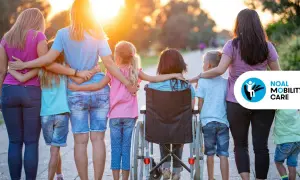 Famiglia unita, con una bambina in carrozzina, esempi di inclusione e superamento della disabilità motoria.