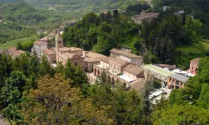 Borgo collinare con edifici in pietra e tetti in tegole, circondato da boschi rigogliosi. Un luogo incantevole da amandola cosa vedere.