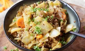 Herzhaftes Gericht aus spitzkohl mit hackfleisch und kartoffeln, garniert mit Petersilie.
