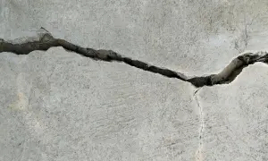 Pęknięcie w betonie, gdzie widać drobne włókno polimerowe wzmacniające strukturę.