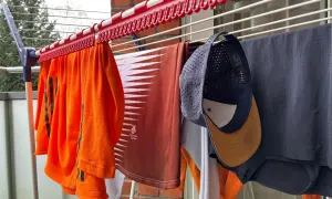 Wäscheleine mit Kleidung, darunter eine orangefarbene Sportbekleidung und eine Kappe zum Reinigen.