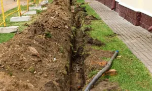 Wygląda na to, że kopany jest rów melioracyjny w granicy działki, z widocznym przewodem i ziemią usuniętą na bok.